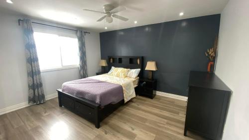 um quarto com uma cama e uma ventoinha de tecto em Spectacular 3 BR 2 WR House - Close to Airport em Toronto