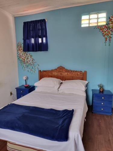 - une chambre avec un grand lit aux murs bleus dans l'établissement No coração da Ilha, à Rio de Janeiro