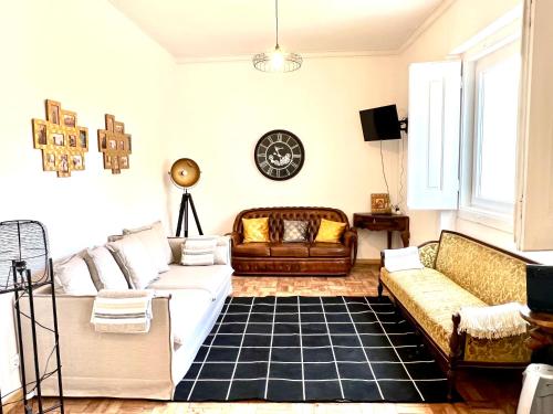 ein Wohnzimmer mit Sofas und einer Uhr an der Wand in der Unterkunft Maison M&M private pool 13 guests in Almeirim