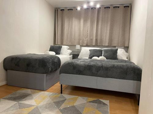 - 2 lits installés l'un à côté de l'autre dans une chambre dans l'établissement Well-preserved cozy1BR flat in LCY with free parking, à Londres