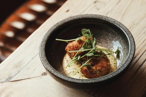a bowl of food on a wooden table at The Woolpack Hotel in Tenterden