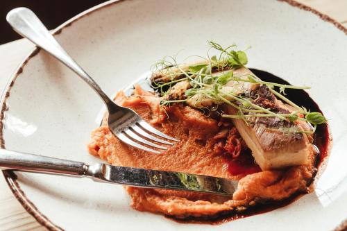 a plate of food with a fork and knife at The Woolpack Hotel in Tenterden