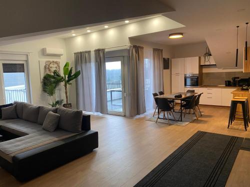ヴェリカ・ゴリツァにある4TREES Airport Apartmentsのリビングルーム(ソファ、テーブル付)、キッチンが備わります。