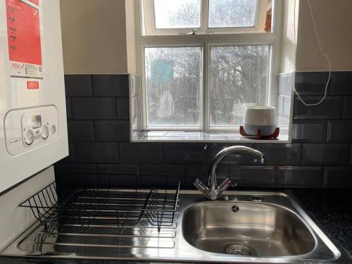 encimera de cocina con fregadero y ventana en 4min walk Uni of East London 1BR, en Londres