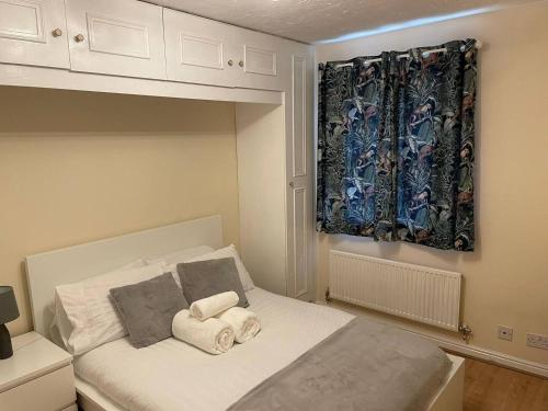 1 dormitorio con 1 cama con toallas en 4min walk Uni of East London 1BR, en Londres