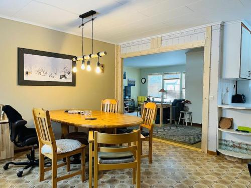 a kitchen and dining room with a wooden table and chairs at Vrijstaand huis in Västerbotten in Norsjö