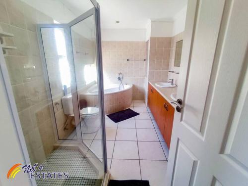 a bathroom with a shower and a tub and a toilet at Waterfront G2 Self Catering Unit in Swakopmund