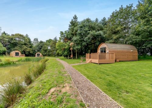 a wooden cabin in a field next to a river at Killerby Old Hall in Scarborough