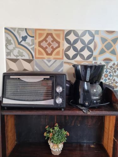 a microwave sitting on a shelf next to a plant at Suite em Paquetá in Rio de Janeiro