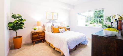 1 dormitorio con 1 cama con almohadas de color naranja y ventana en H4N Furnished Apartments Near JBLM, en Lakewood