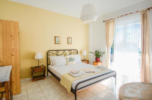 sypialnia z łóżkiem i dużym oknem w obiekcie Heracles Guesthouse w mieście Rovies
