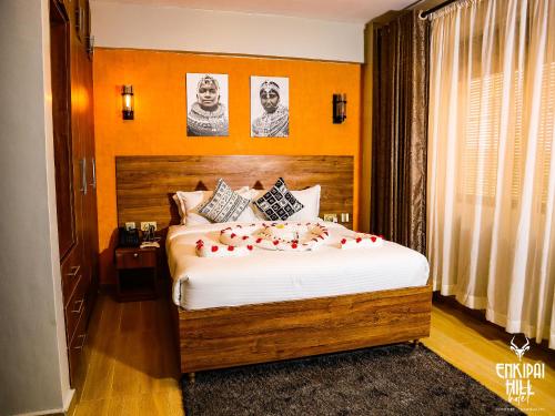 Un dormitorio con una cama con rosas. en Enkipai Hill Hotel en Narok
