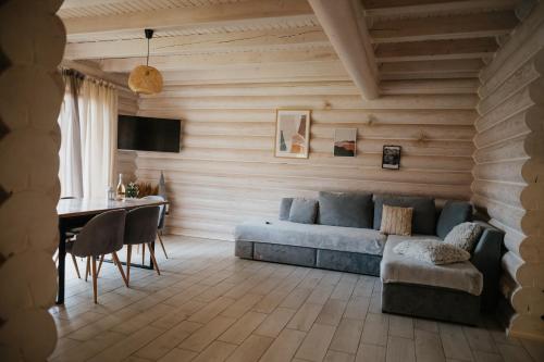 ein Wohnzimmer mit einem Sofa und einem Tisch in der Unterkunft Vila Mila in Mykulytschyn