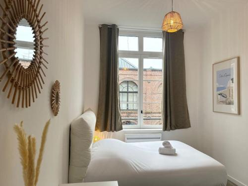 une chambre avec un lit, un miroir et une fenêtre dans l'établissement Vieux-Lille Appartement rénové avec une chambre, à Lille