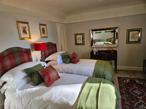 a hotel room with two beds and a mirror at Craggan in Ballater