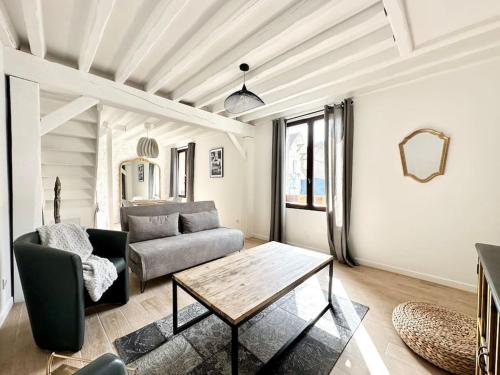 un salon avec un canapé et une table dans l'établissement Maison de Ville Rénovée avec Charme, à Pont-Sainte-Maxence