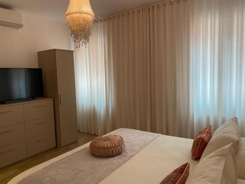 - une chambre avec un lit, une télévision et des rideaux dans l'établissement MURANO Place - MISTRO House, à Murano