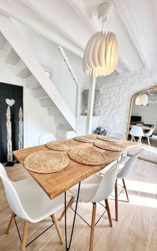 une salle à manger avec une table en bois et des chaises blanches dans l'établissement Maison de Ville Rénovée avec Charme, à Pont-Sainte-Maxence