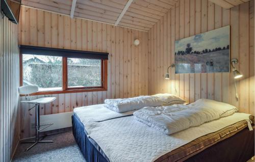 ein Schlafzimmer mit einem Bett in einer Holzwand in der Unterkunft 4 Bedroom Awesome Home In Tranekr in Skattebølle