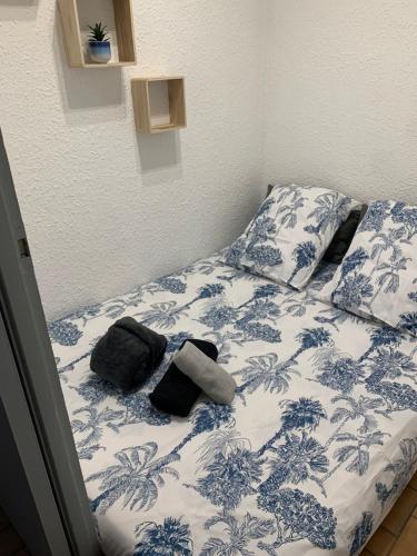 un lit avec des draps et des oreillers bleus et blancs dans l'établissement Appartement 1ere ligne Palavas les flots, à Palavas-les-Flots