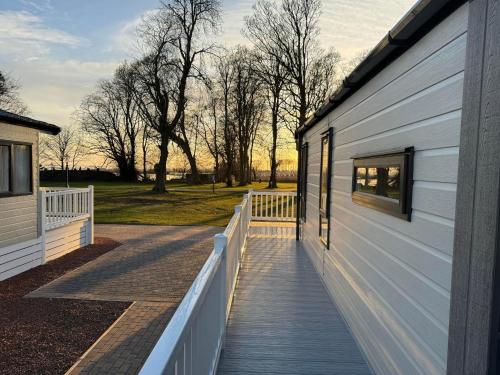 a wooden walkway next to a white building at Seaton Estate in Arbroath