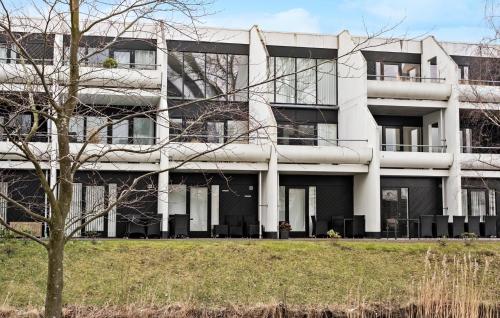 a white building with a tree in front of it at 1 Bedroom Beautiful Home In Helsingør in Helsingør