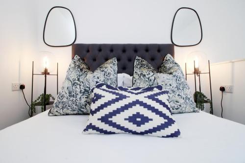 sypialnia z łóżkiem z niebiesko-białymi poduszkami w obiekcie Charming 2BR Cardiff Oasis with Private Courtyard w Cardiff