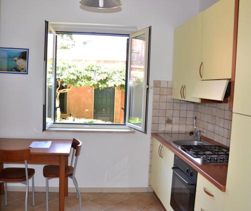 a small kitchen with a table and a window at Residenza La Vigna in Parghelia
