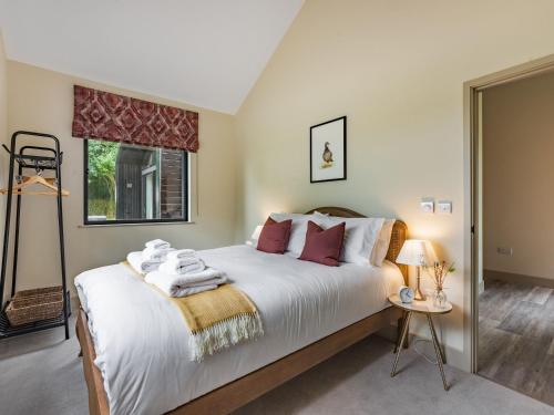 a bedroom with a large white bed and a window at Partridge in East Ilsley