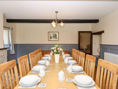 a long table with white plates and flowers on it at Nempnett Farmhouse in Bristol