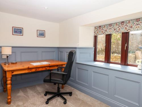 an office with a wooden desk and a chair at Nempnett Farmhouse in Bristol