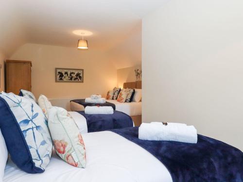 a bedroom with two beds with blue and white pillows at Nempnett Farmhouse in Bristol