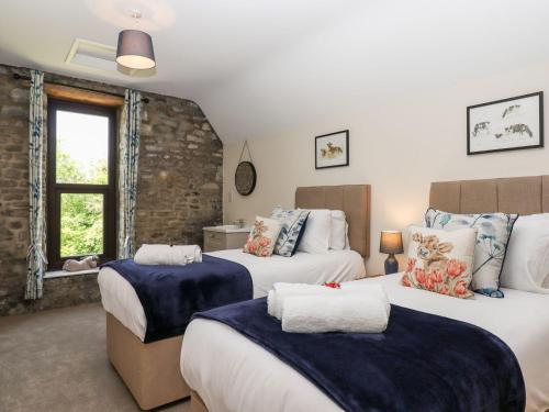 a bedroom with two beds and a window at Nempnett Farmhouse in Bristol