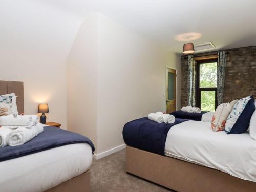 a bedroom with two beds and a window at Nempnett Farmhouse in Bristol