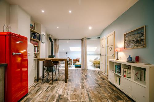 uma sala de estar com um frigorífico vermelho e uma mesa em Le Dôme et son jacuzzi em Grazac