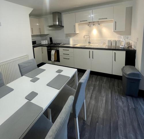 a kitchen with a table and chairs and a sink at The Home Away From Home in Great Harwood