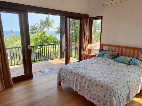 - une chambre avec un lit et un balcon dans l'établissement Роскошная вилла 4 спальни прямо на берегу океана на пляже Jasri beach, à Kusamba