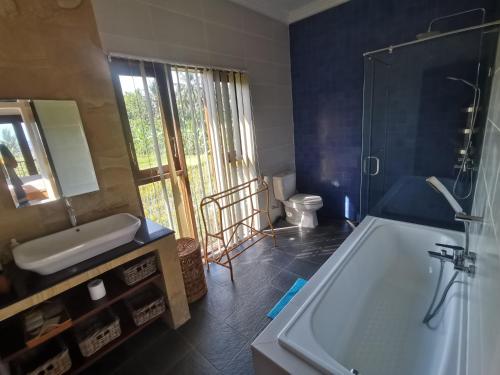 La salle de bains est pourvue d'une baignoire, d'un lavabo et de toilettes. dans l'établissement Роскошная вилла 4 спальни прямо на берегу океана на пляже Jasri beach, à Kusamba