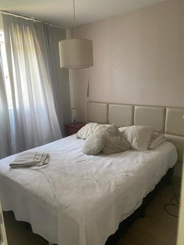Un dormitorio con una cama blanca con almohadas. en Apê da Loren, en Vespasiano