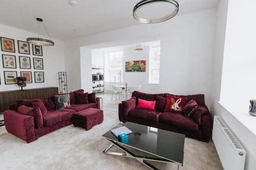 a living room with two couches and a table at Grade II Mill Townhouse in Leeds with Free Parking which Sleeps 6 in Leeds