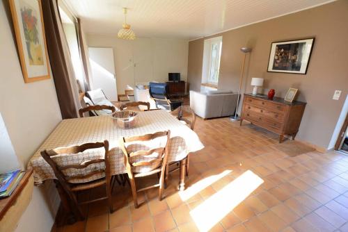 une salle à manger avec une table et des chaises et un salon dans l'établissement Les Bardilles - dans la campagne à 3 km de SARLAT, à Sarlat-la-Canéda