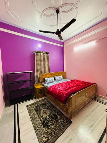 1 dormitorio con 1 cama con paredes de color púrpura y techo en Sardar Patel Homestay, en Ayodhya