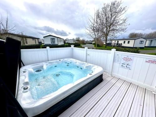 南塞爾尼的住宿－Paws Lodge, Hot Tub, Pet Friendly，甲板上的一个热水浴缸