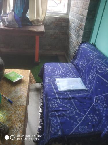 a bed in a room next to a table at Gouri Bhawan in Kolkata