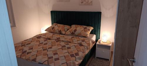 ein kleines Schlafzimmer mit einem Bett mit einem grünen Kopfteil in der Unterkunft Villa SHAMS in Travnik