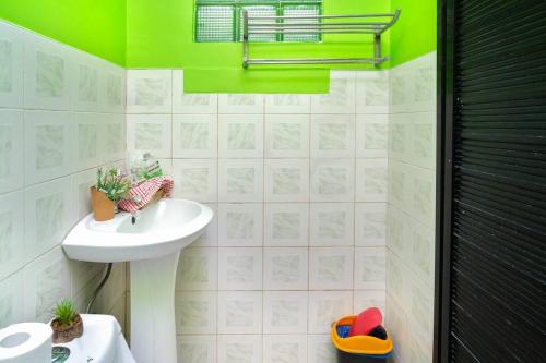 a bathroom with a sink and a green wall at Golden V Executive Homes Unit I in Malolos