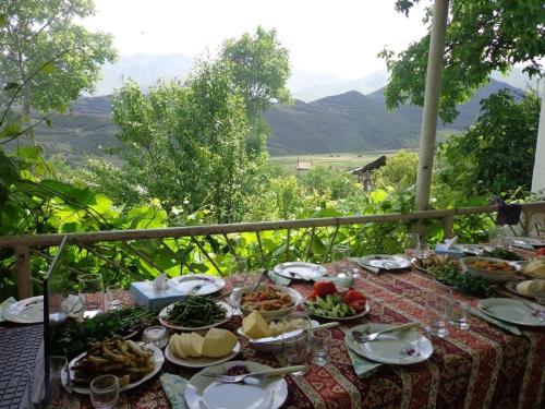 una mesa con platos de comida con vistas en LANJ IN Eco Garden/ Guest House, en Nurrnus