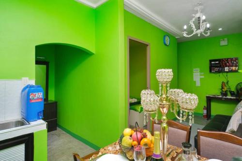 a green room with a table with a bowl of fruit at Golden V Executive Homes Unit I in Malolos