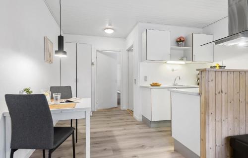 a kitchen and dining room with a table and chairs at Holiday Home Blåvandvej Blåvand Xii in Blåvand