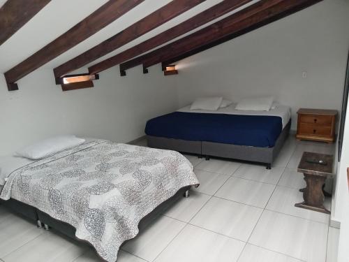 1 Schlafzimmer mit 2 Betten in einem Zimmer in der Unterkunft Hostal Villa Rosita in Villa de Leyva